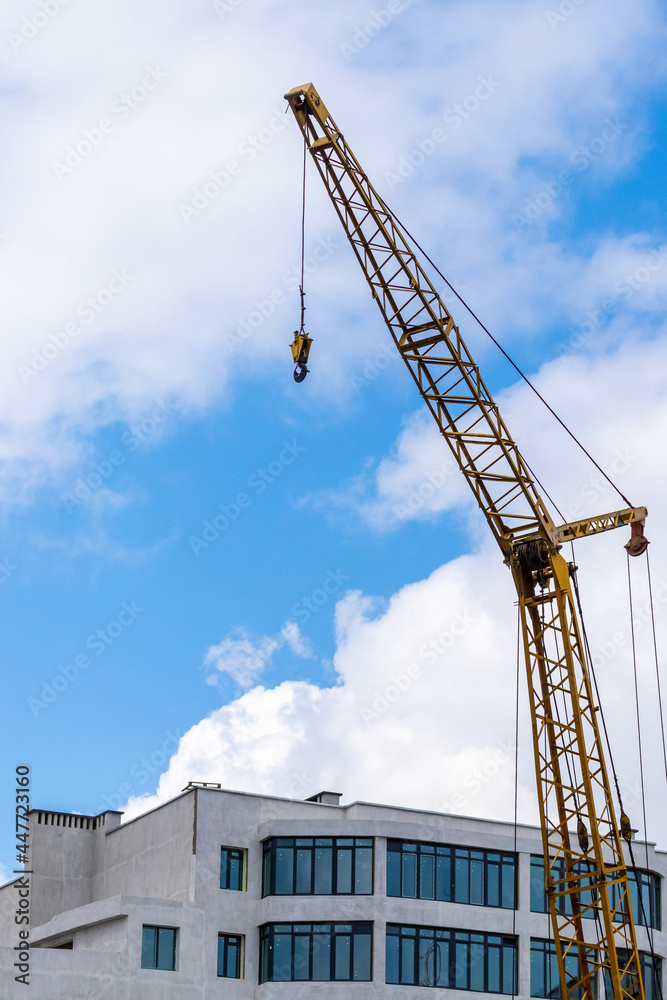 Construction crane on a background of the sky near the new building Construction crane on a background of the sky near the new building