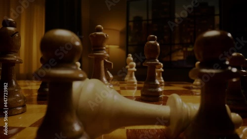 Person gamer hand hits white opponent chess queen closeup