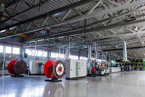 Plastic pipe modern production line interior. Air funnels, electric cabinets. Red bobbins, metal openwork roof. Atyrau, Kazakhstan, Chevron factory. 