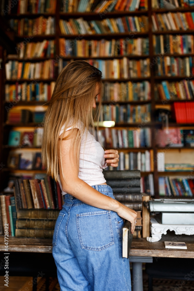 Beautiful female student or teenager in a university library or bookstore