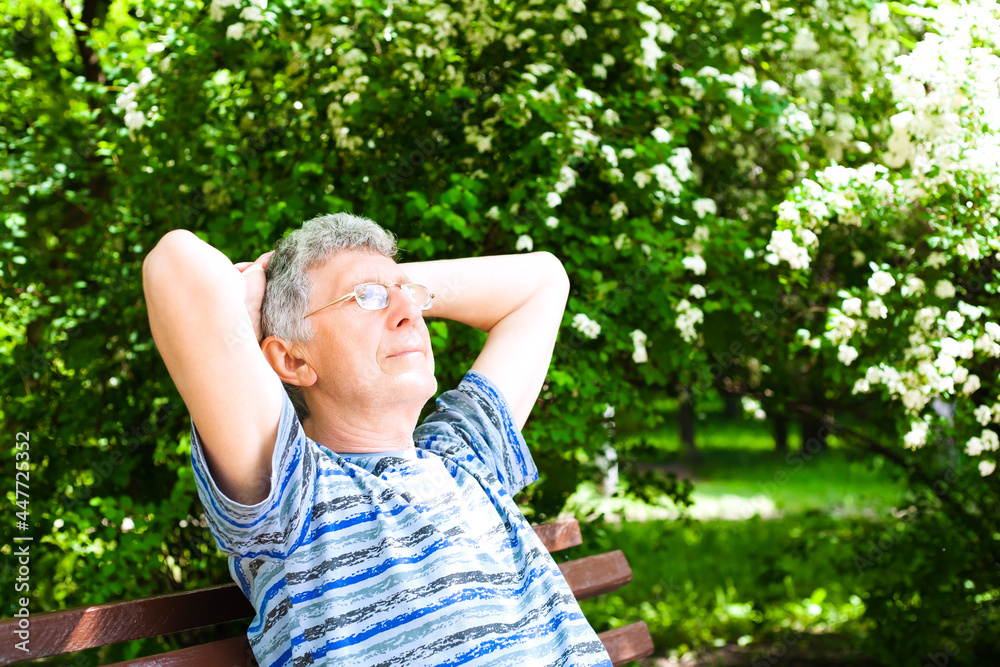 Senior man rests on a bench in the park in sunny day. Senior man rests on a bench in the park in sunny day.