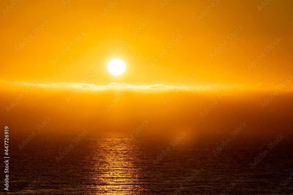 Bright sunset with large yellow sun in Ireland