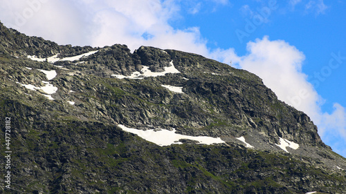 Snow capped rocky peak. View of a mountain range in summer or summer with snow at the top.