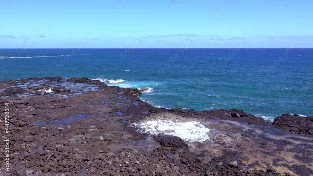 The waves lap the reefs on the shore, stirring up the white waves. A view of the seashore in Hawaii, USA. June 2019. The waves lap the reefs on the shore, stirring up the white waves. A view of the seashore in Hawaii, USA. June 2019.