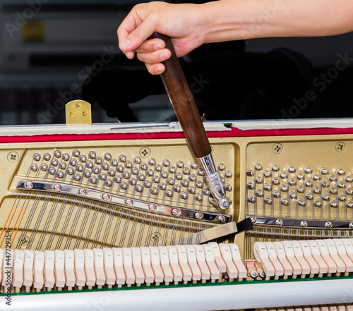 Piano tuner tuning upright piano