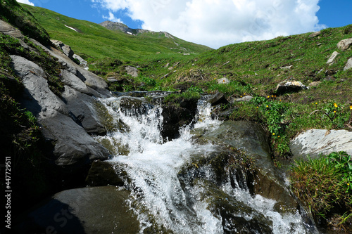 View of the water of a waterfall flowing between the rocks of a mountain in summer.