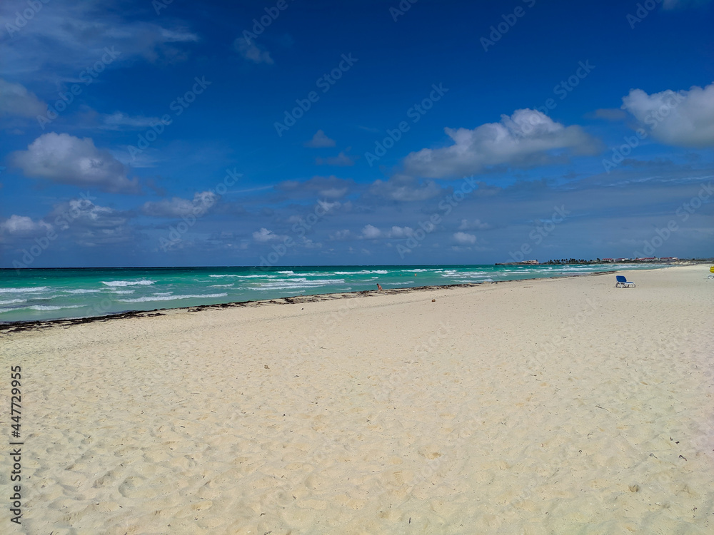 Cayo Coco, Cuba, 16 may 2021: Tryp Cayo Coco's sandy beach with sun loungers and azure ocean. People relax, sunbathe and swim in the waves against the background of the blue sky.