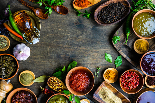 Overhead view of assorted herbs, spices, sauces and seasoning on a table