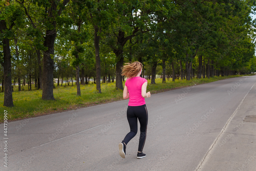 Young woman in sportswear running outdoors on green trees background. Sport, healthy way of life, runners training concept. Young woman in sportswear running outdoors on green trees background. Sport, healthy way of life, runners training concept.