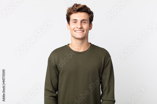 young handsome man smiling cheerfully and casually with a positive, happy, confident and relaxed expression