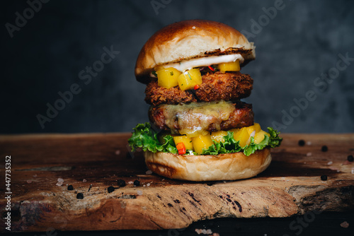 Burger with mango and shrimps in tempura on wooden board