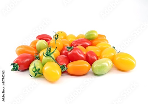 Colorful mini plum tomatoes on white backgrounds . Colors are red  green  yellow and orange