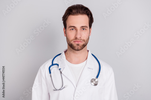 Photo of confident pretty young guy doctor workwear standing looking you isolated grey color background