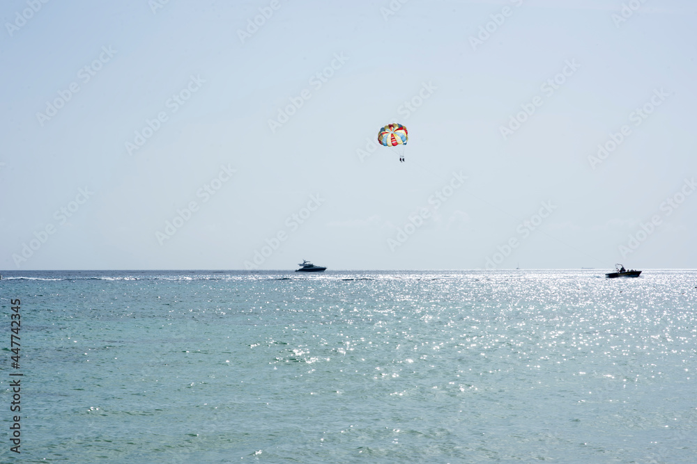 Parasailing against the sky and over the Caribbean sea in the coast of Cozumel island in Mexico