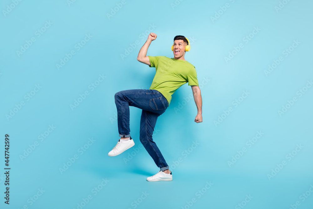 Full length body size photo man in headphones gesturing like winner isolated pastel blue color background
