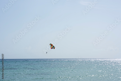 A tourist parasailing over the Caribbean Sea near the coast of Cozumel Island, Mexico