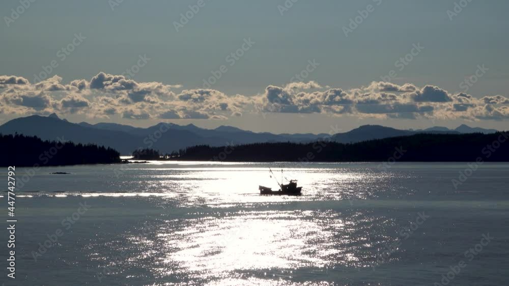 Work boat sailing on the lake. Morning sunlight mapped the surface of the lake. Ketchikan, Alaska is truly the beginning of the Work boat sailing on the lake. Morning sunlight mapped the surface of the lake. Ketchikan, Alaska is truly the beginning of the