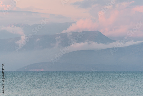 Albania coast surrounded by clouds during sunset seen from Corfu island in Greece