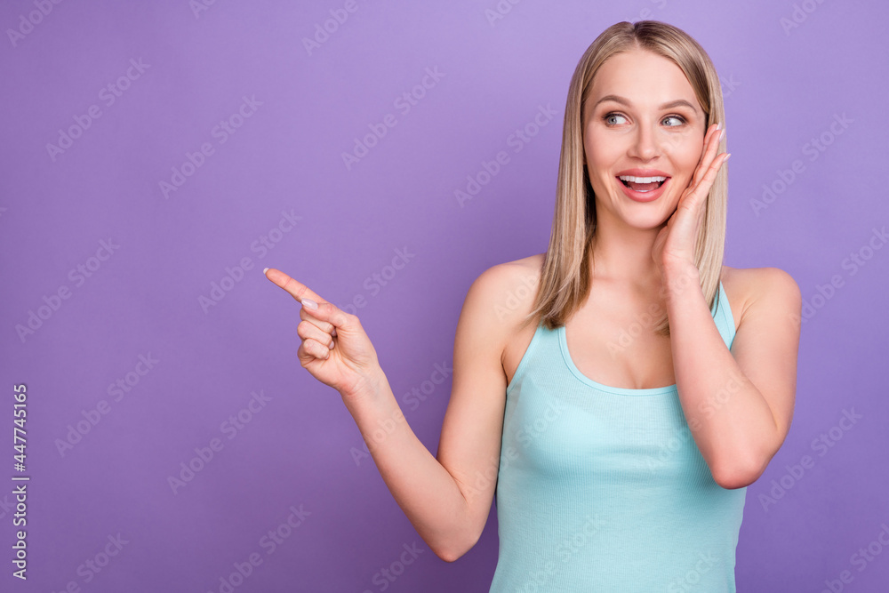Photo of hooray blond millennial lady point look empty space wear blue top isolated on violet color background Photo of hooray blond millennial lady point look empty space wear blue top isolated on violet color background