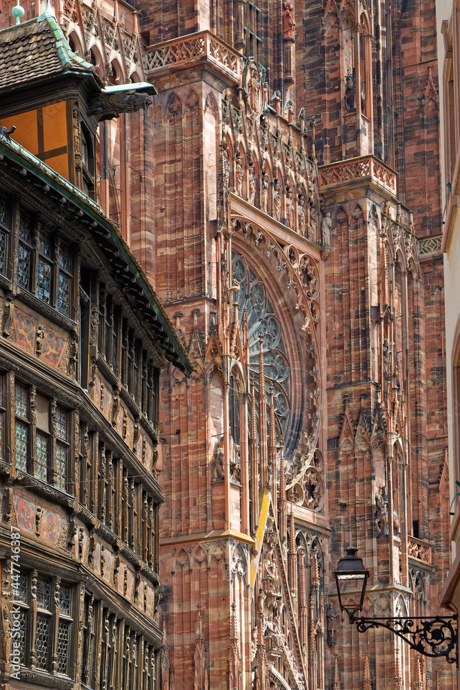Obraz premium STRASBOURG, FRANCE, June 23, 2021 : Strasbourg Cathedral and Kammerzell house facade, an old and traditionnal architectural example of Strasbourg city houses.