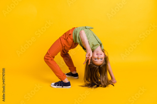 Obraz na plátne Full length body size photo little girl showing v-sign doing handstand isolated