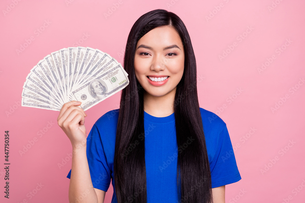 Photo of cheerful positive happy woman hold hands cash dollar money profit isolated on pink color background Photo of cheerful positive happy woman hold hands cash dollar money profit isolated on pink color background