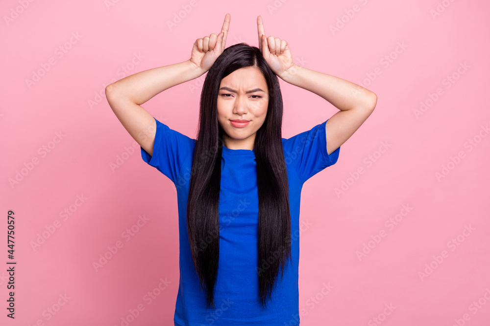 Photo of young attractive woman hold fingers head horns evil frightening isolated on pink color background Photo of young attractive woman hold fingers head horns evil frightening isolated on pink color background