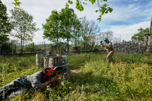 Teams in camouflage clothes playing paintball together photo