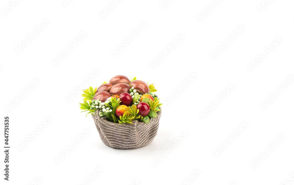 Obraz premium Artificial mushrooms and flowers in a basket with burlap.