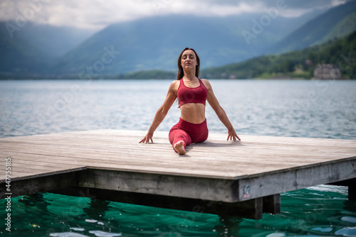 Flexible woman siting in Front Splits pose and doing yoga photo