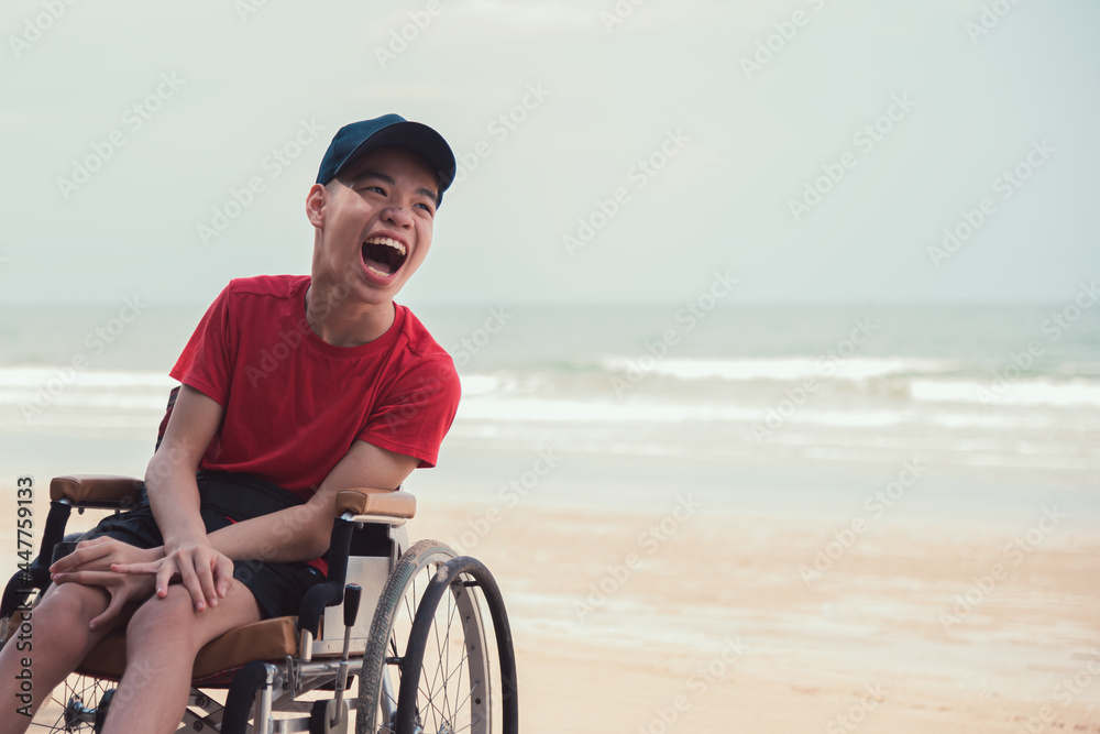 Asian happy disabled teenage boy, Activity outdoors with family on the beach background, People having fun and diverse people concept.