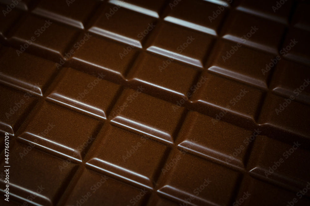 Fototapeta premium Tiles of black chocolate as background, close-up with selective focus. Hight quality photo
