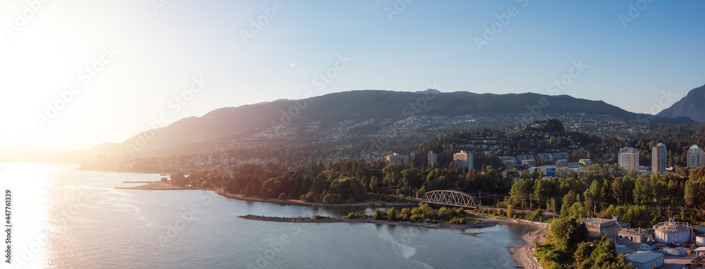 Fototapeta premium West Vancouver, British Columbia, Canada. Aerial Panoramic View of a modern cityscape on the Pacific Ocean Coast during an Summer sunny Sunset.