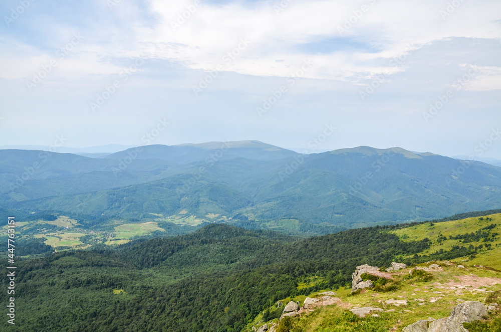 Carpathian Mountains. Panorama of green hills in summer mountains. Beautiful green mountain forest under blue sky. Carpathian Mountains. Panorama of green hills in summer mountains. Beautiful green mountain forest under blue sky.