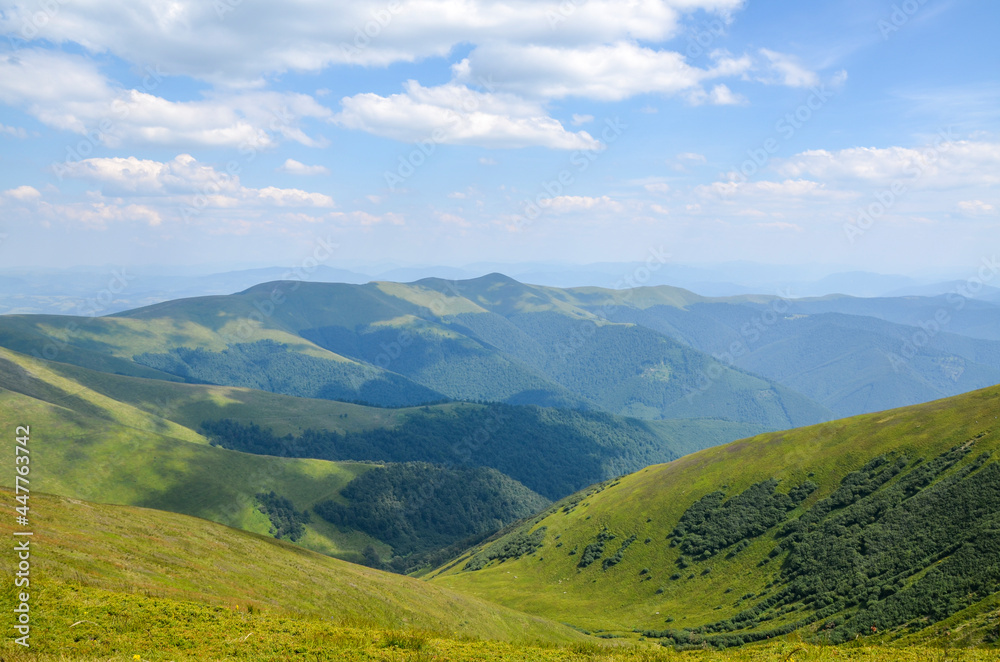 Scenic view of green grassy mountain ridge against blue cloudy sky. Carpathian mountains, Ukraine
