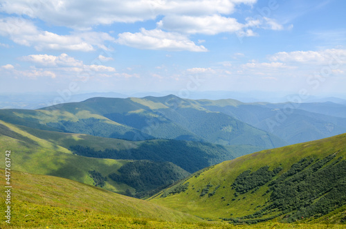 Scenic view of green grassy mountain ridge against blue cloudy sky. Carpathian mountains  Ukraine