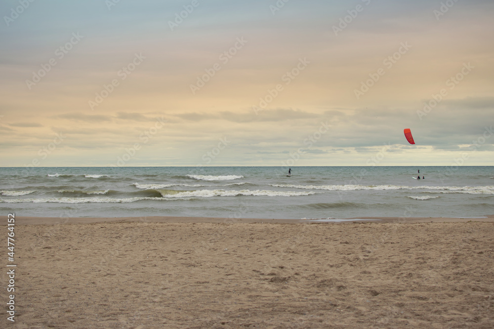 Obraz premium kitesurfing on beach with sunset