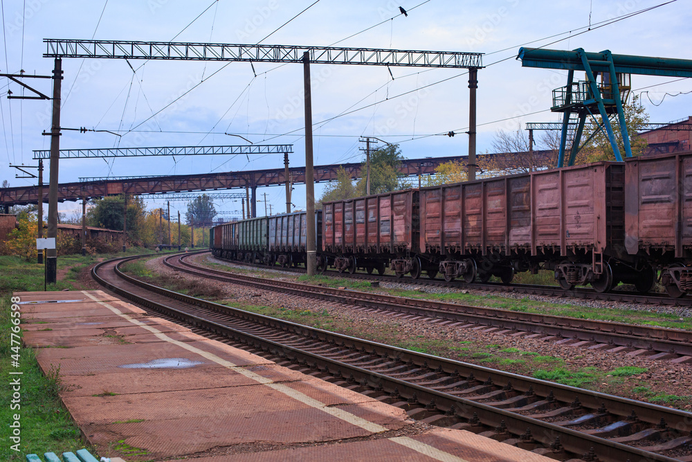 A train of railway freight cars stands at the station. The time of shooting in autumn.