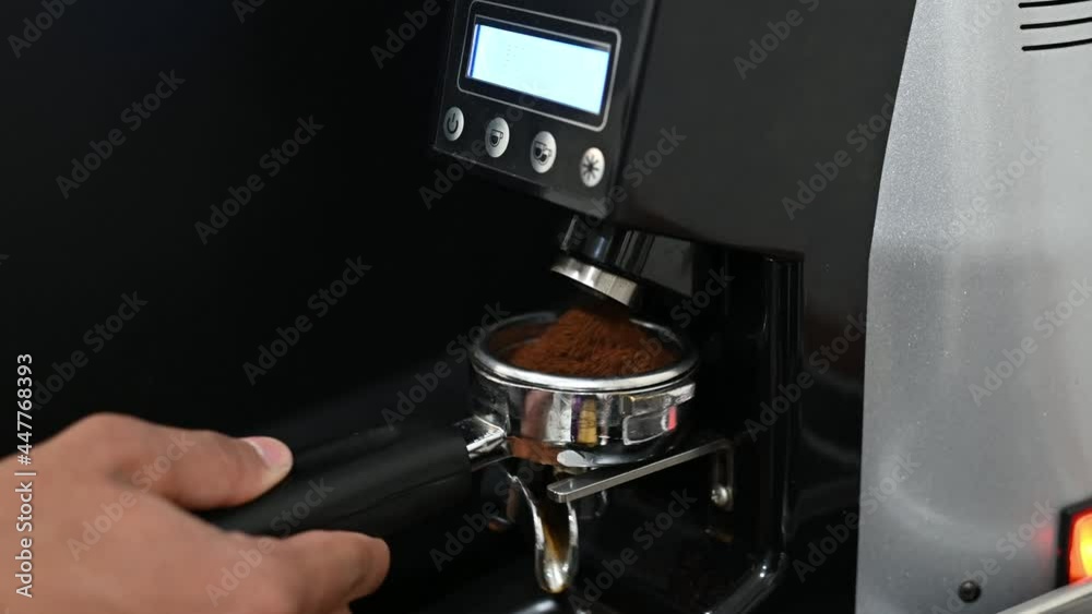 Professional barista worker use grinder machine to grind fresh coffee beans for make hot beverage at Professional barista worker use grinder machine to grind fresh coffee beans for make hot beverage at
