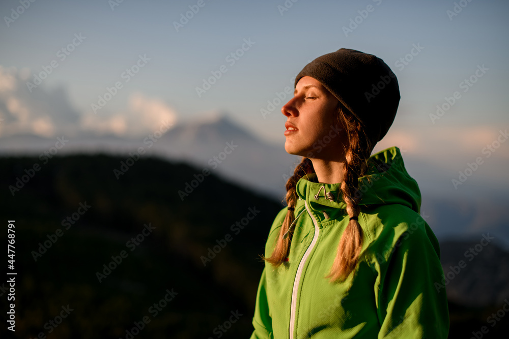portrait of woman with closed eyes against background of sky and mountains