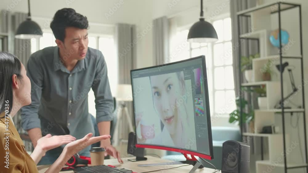 Asian Male And Female Professional Editors Arguing While Working In Photo Editing App / Software On A Personal Computer. Photo Editors Retouching Photos Of A Beautiful Girl
