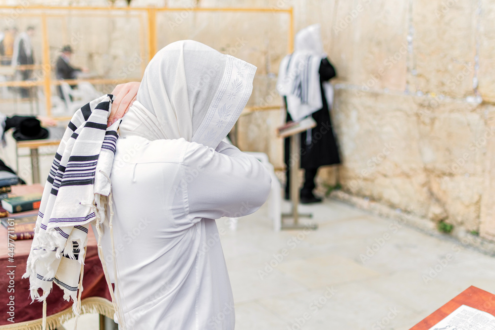 Young Orthodox Jewish man praying with shawl (tallit), at the Western Wall.