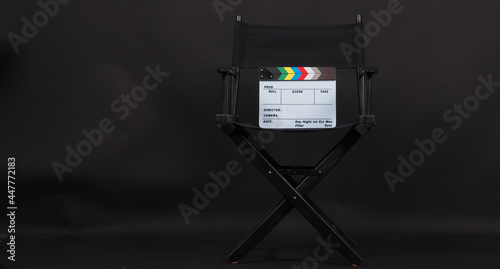 Clapper board or movie slate with director chair use in video production and cinema industry.It is put on black background.