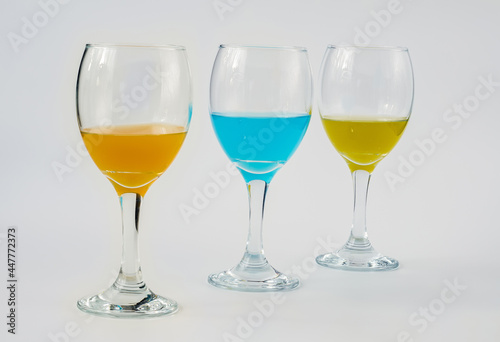 Wine glasses with yellow, blue and orange wine