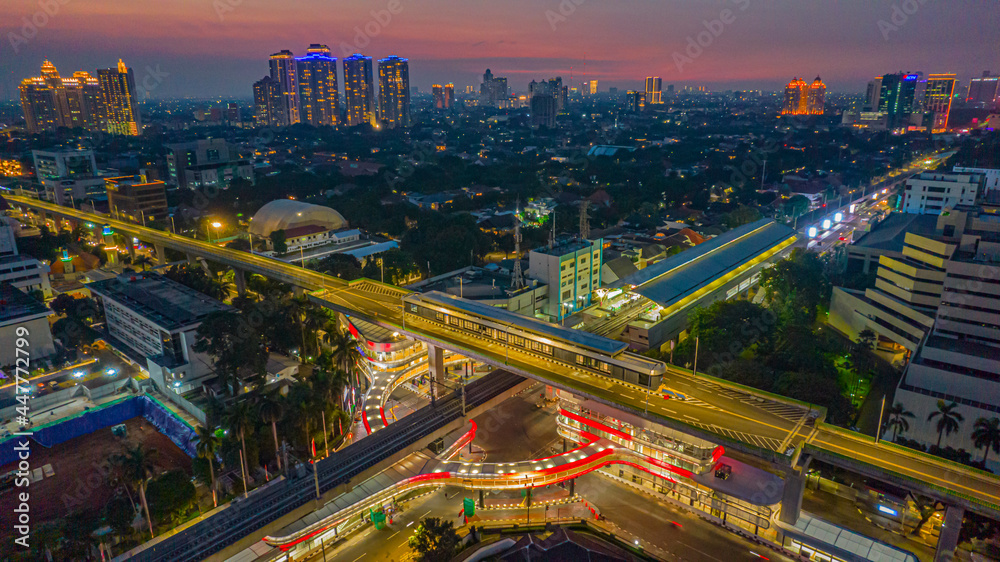 Fototapeta premium Aerial view of articulated city buses arriving and leaving at bus station near main railway station MRT line at Kebayoran Baru. Jakarta, Indonesia, July 29, 2021