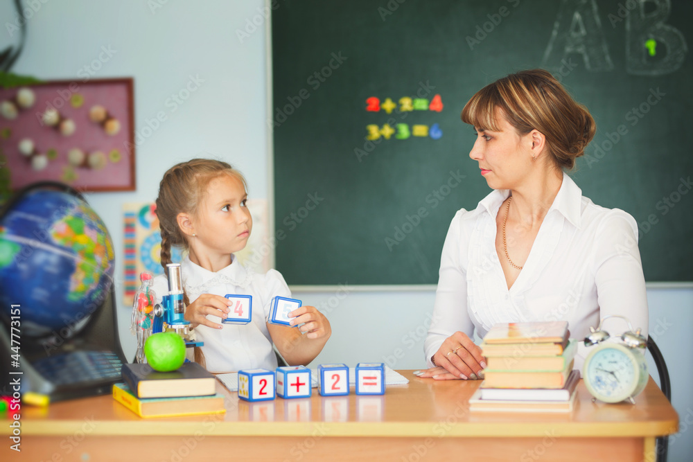 Cute schoolgirl and her teacher in a classroom Cute schoolgirl and her teacher in a classroom