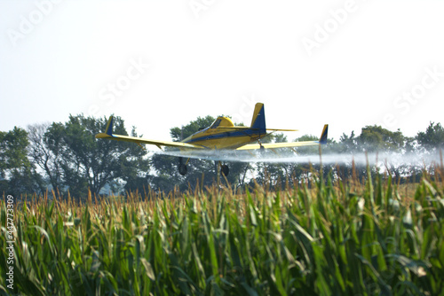 Low flying Crop Duster applying insecticide to the corn fields
