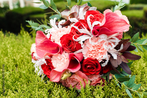 Red bridal bouquet of peonies and roses. Scenery for the wedding. photo