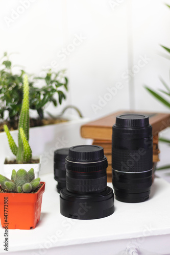 Photographic camera lenses on a desk, with a white background.