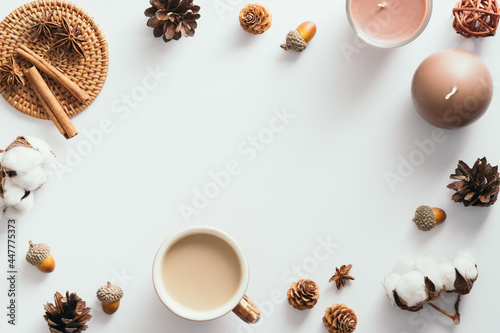 Autumn composition. Flat lay coffee cup, candles, cinnamon sticks, cones, acorns on white background. Nordic, hygge, cozy home concept